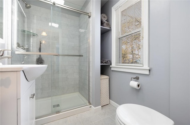 bathroom featuring toilet, baseboards, a shower stall, and vanity