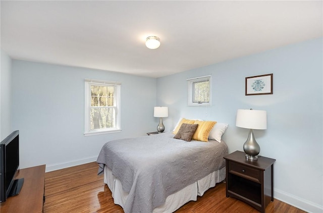 bedroom with baseboards and wood finished floors