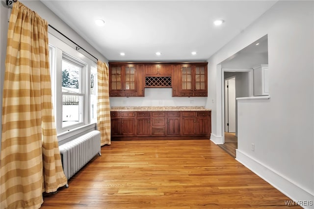 bar with recessed lighting, baseboards, light wood finished floors, and radiator