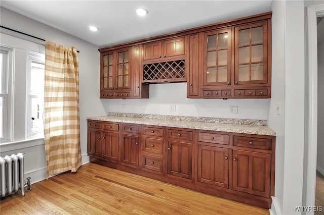 bar with radiator heating unit, light wood-style floors, recessed lighting, and a wealth of natural light