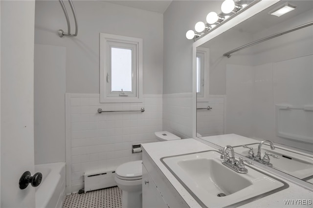 full bathroom with tile walls, wainscoting, vanity, a baseboard heating unit, and toilet