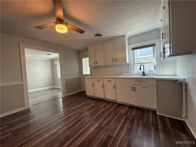 kitchen with a sink, light countertops, a ceiling fan, and dark wood-style floors