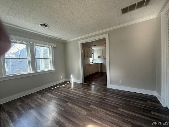 unfurnished room with crown molding, dark wood-style flooring, and visible vents
