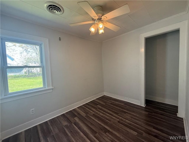 unfurnished bedroom with visible vents, crown molding, dark wood-style flooring, baseboards, and a ceiling fan
