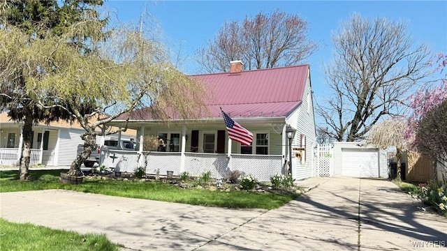 bungalow-style house with a chimney, concrete driveway, a porch, and metal roof