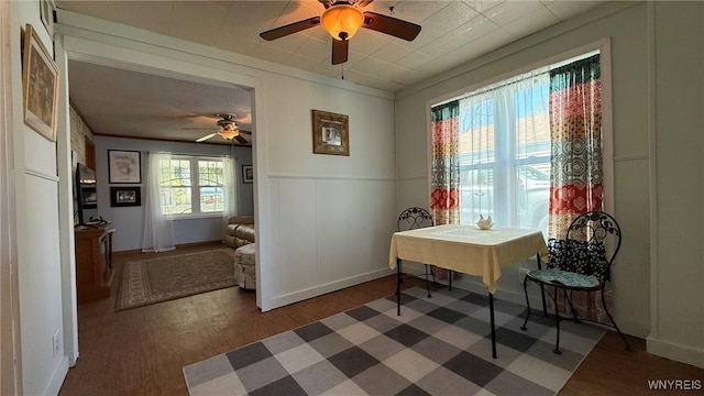 dining room with baseboards, ceiling fan, and a wainscoted wall