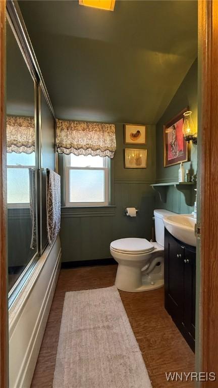 bathroom featuring toilet, vaulted ceiling, and vanity