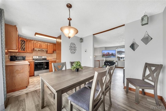 dining space featuring light wood-style floors and a textured ceiling