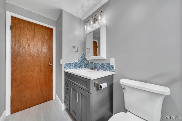 bathroom featuring vanity, baseboards, and toilet