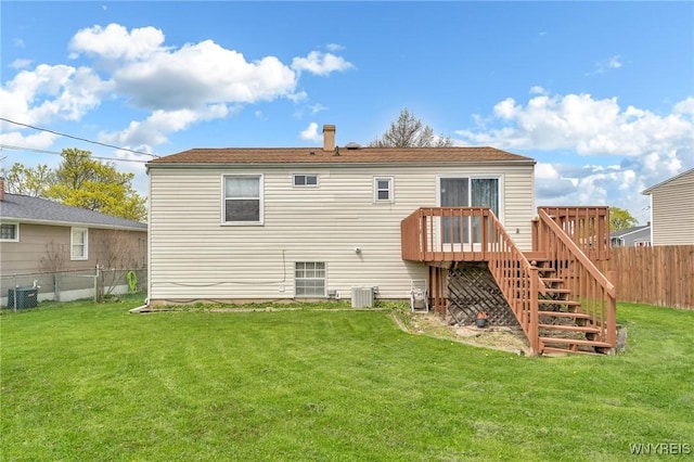 rear view of property featuring a lawn, a deck, central air condition unit, a fenced backyard, and stairs
