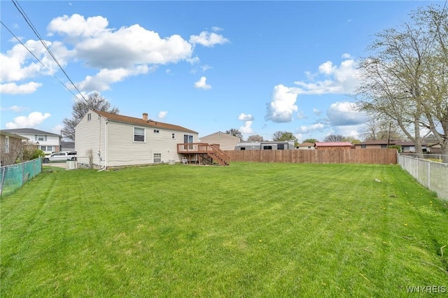 view of yard featuring a fenced backyard, stairs, and a wooden deck