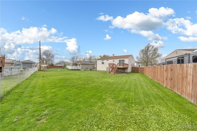view of yard with stairway, a deck, and a fenced backyard
