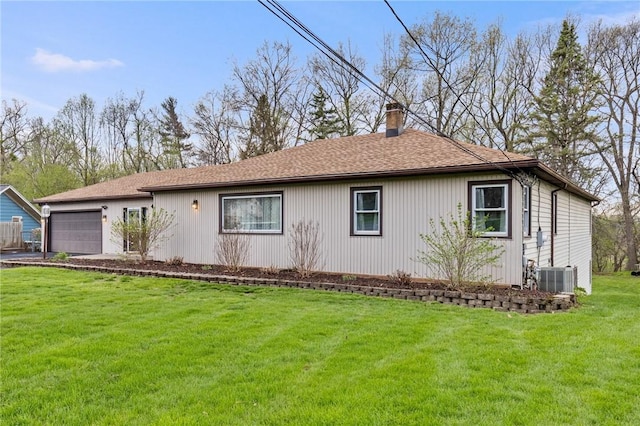 view of front of property with an attached garage, a chimney, and a front lawn