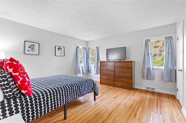 bedroom featuring light wood-style floors, baseboards, and visible vents