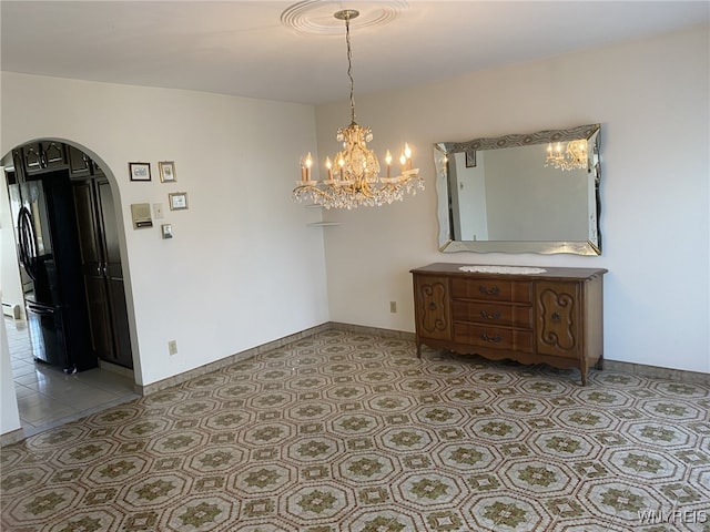 dining room featuring an inviting chandelier, arched walkways, and baseboards