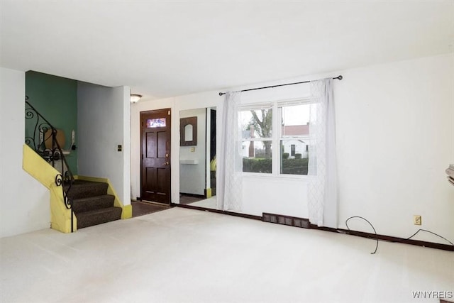 carpeted foyer with stairway