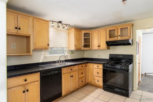 kitchen featuring dark countertops, a sink, under cabinet range hood, glass insert cabinets, and black appliances