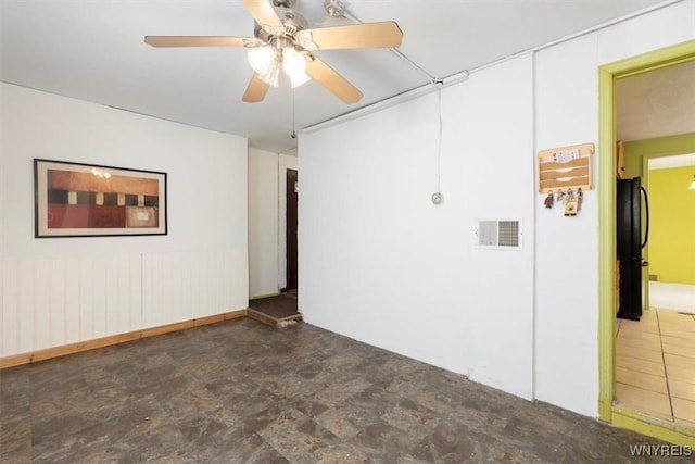 spare room featuring a ceiling fan and visible vents