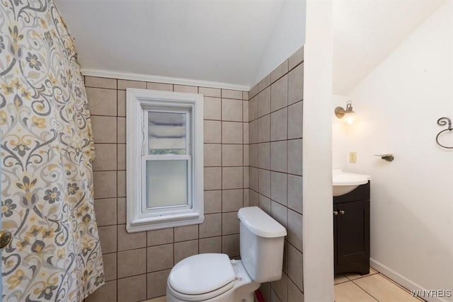 bathroom featuring vanity, tile patterned flooring, toilet, and tile walls
