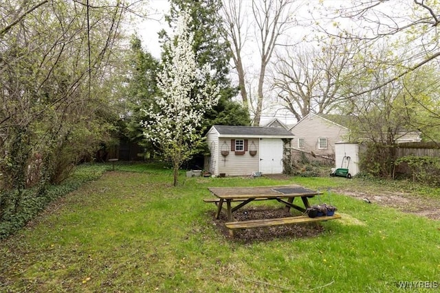 view of yard featuring fence, an outdoor structure, and a shed