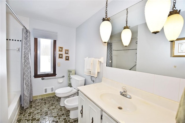 bathroom with vanity, toilet, baseboards, visible vents, and a bidet