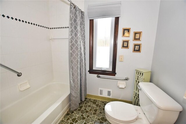 bathroom featuring toilet, baseboards, visible vents, and plenty of natural light