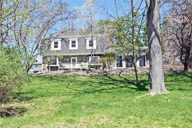 view of front of home featuring a shingled roof and a front yard