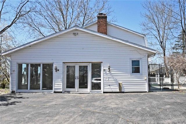 rear view of property featuring fence and a chimney