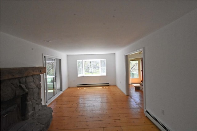 150 Monroe Dr, Horseheads, NY 14845 - unfurnished living room with a baseboard heating unit, a stone fireplace, and light wood-style flooring