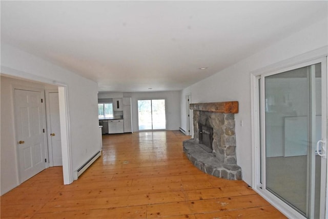150 Monroe Dr, Horseheads, NY 14845 - unfurnished living room with a stone fireplace, baseboard heating, and light wood-style flooring