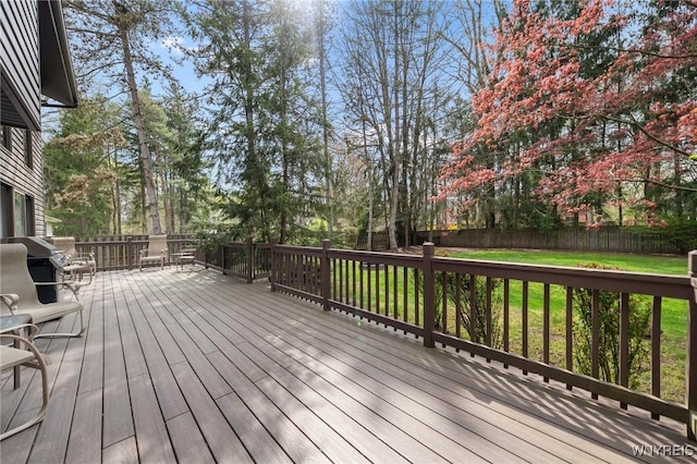 wooden terrace with a fenced backyard, a yard, and area for grilling