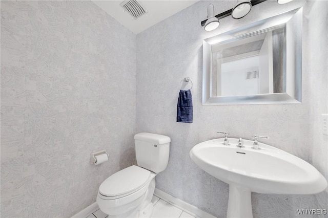 bathroom with toilet, baseboards, and visible vents