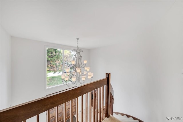 stairway featuring a notable chandelier