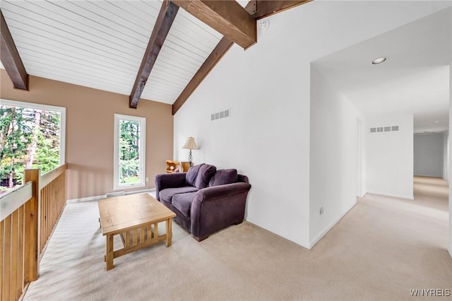 living area with visible vents, lofted ceiling with beams, baseboards, and light colored carpet