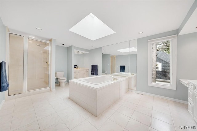 bathroom featuring toilet, tile patterned floors, a shower stall, a skylight, and a garden tub