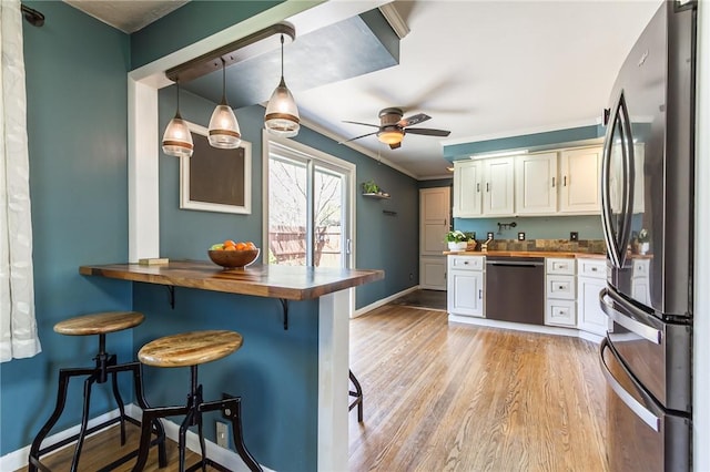 kitchen featuring appliances with stainless steel finishes, a breakfast bar area, and wooden counters