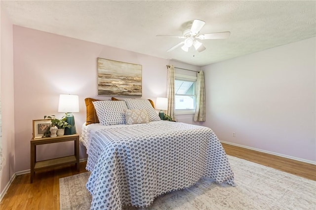 bedroom featuring baseboards, a ceiling fan, and wood finished floors