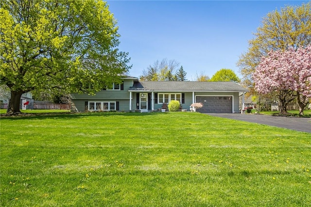 tri-level home with driveway, a front yard, and a garage