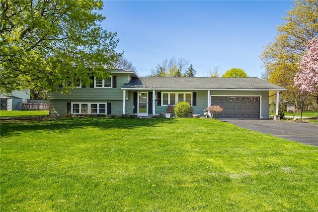 split level home with an attached garage, driveway, and a front lawn