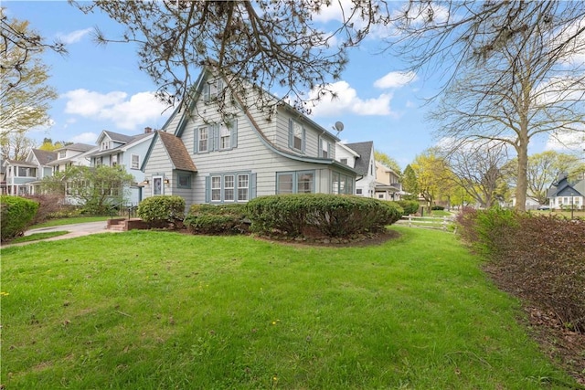 view of side of property featuring a lawn and a residential view
