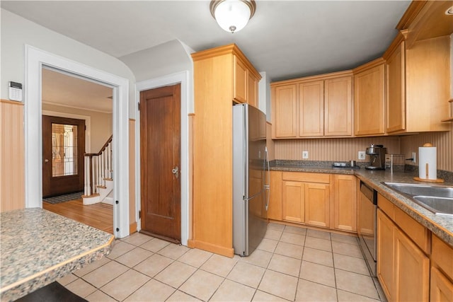 kitchen with a sink, appliances with stainless steel finishes, and light tile patterned floors