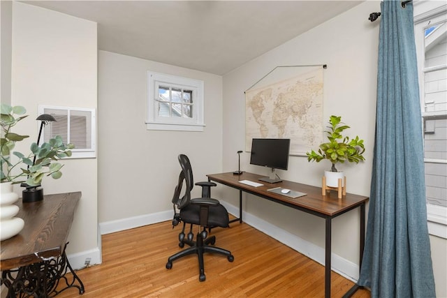 office space featuring baseboards and light wood-type flooring