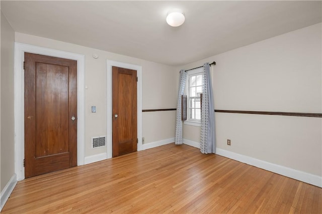 unfurnished bedroom with baseboards, visible vents, and light wood-style flooring
