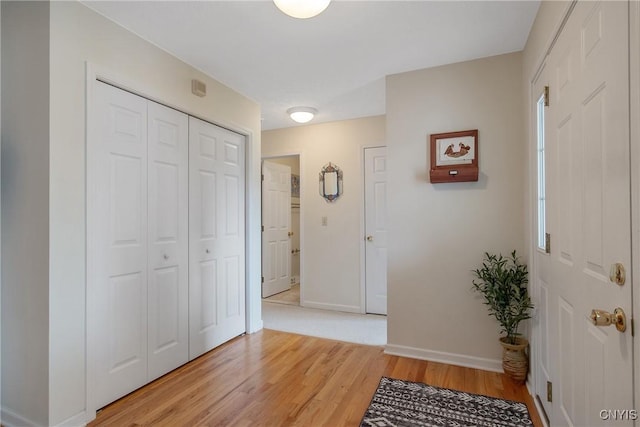 foyer with baseboards and light wood finished floors