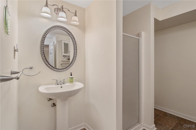 full bathroom featuring baseboards and a stall shower