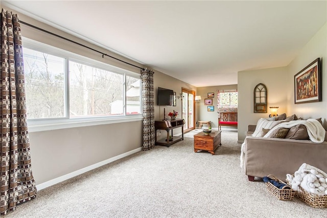 carpeted living area with baseboards