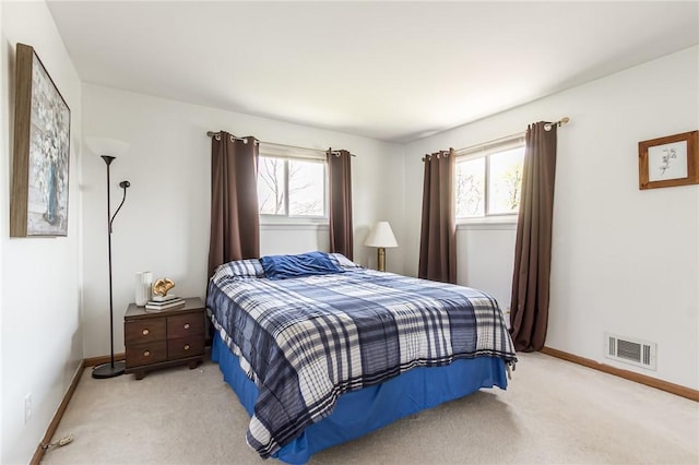 bedroom with multiple windows, light colored carpet, and visible vents