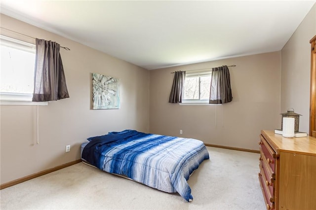 bedroom featuring baseboards and light colored carpet