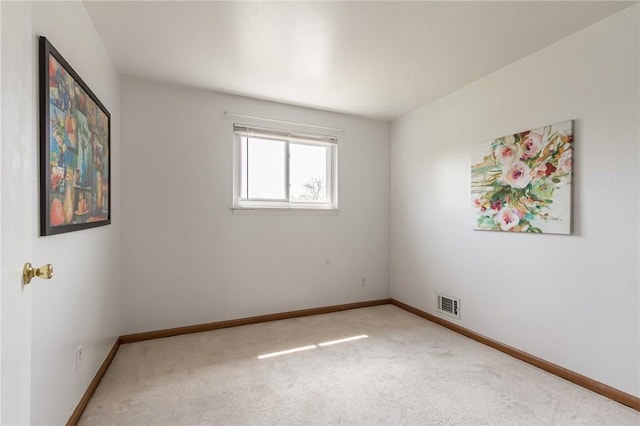 carpeted empty room featuring visible vents and baseboards