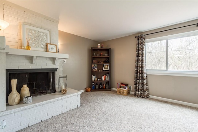 living area featuring carpet floors, baseboards, and a brick fireplace